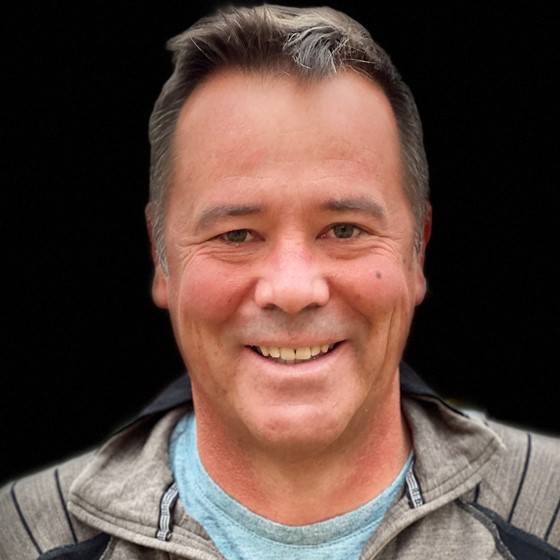 Rob Naeser, Senior Environmental Scientist, stands in business casual attire in front of a black background.